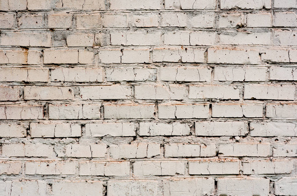 Текстура кирпичной стены с трещинами и царапинами, которые могут быть использованы в качестве фона - Фото, изображение