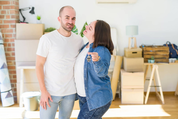 Nuori pari hymyilee erittäin onnellinen osoittaa avaimet uuden kodin, liikkuvat ja ostaa uuden Apartmet käsite
 - Valokuva, kuva