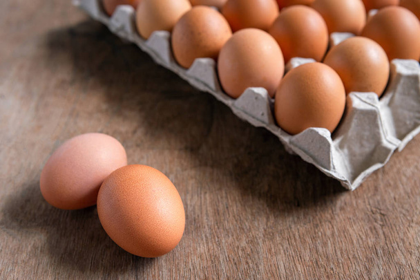 Fresh chicken eggs eggs in paper tray,egg carton on wooden background. - Фото, изображение