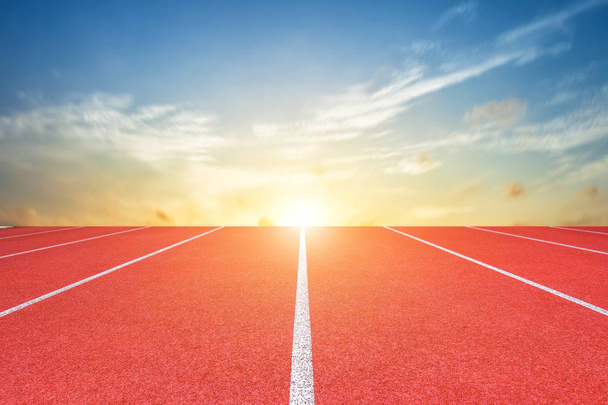 White lines of stadium and texture of running racetrack red rubber racetracks or Athlete track or running track with blue sky white cloud,sky sunset background. - 写真・画像
