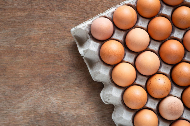 Fresh chicken eggs eggs in paper tray,egg carton on wooden background. - Foto, afbeelding