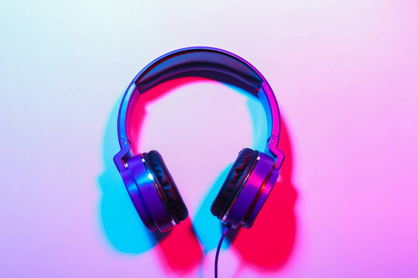 Stylish headphones on color background, top view - Fotó, kép