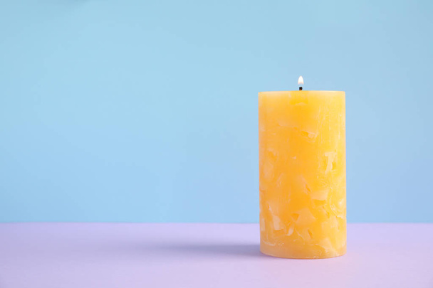 Alight wax candle on color background. Space for text - Фото, зображення