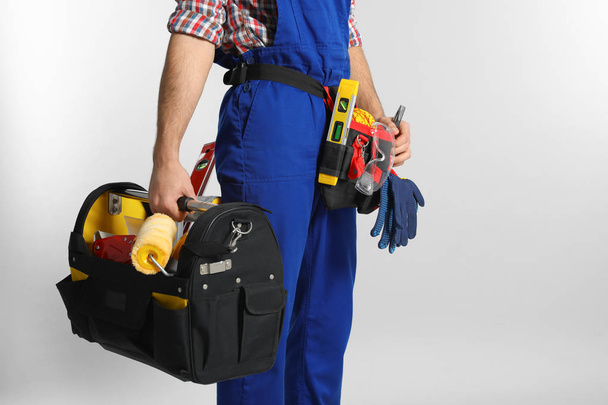 Construction worker with set of tools on light background, closeup. Space for text - Фото, изображение