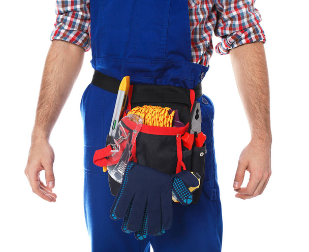 Construction worker with tool belt on white background, closeup - Fotó, kép