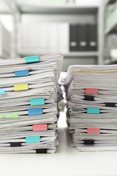 Stacks of documents with paper clips on office desk - 写真・画像