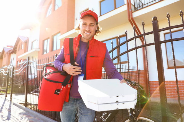 Male courier delivering food in city on sunny day - Foto, imagen