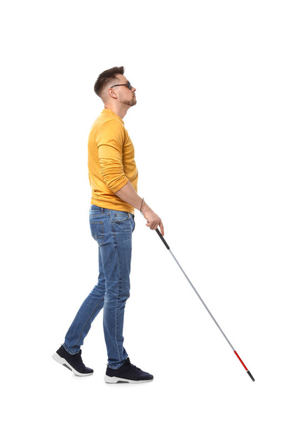 Blind man in dark glasses with walking cane on white background - Foto, afbeelding