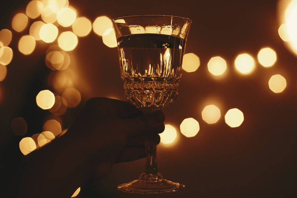 Happy New Year eve party. Hand holding champagne glass on backgr - Fotoğraf, Görsel