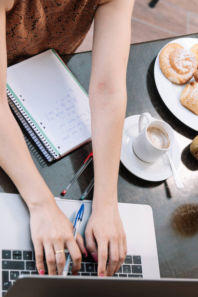 Draufsicht auf Frauenhände, die auf einem Laptop schreiben - Espresso-Kaffee, - Foto, Bild