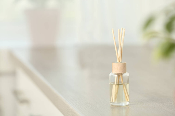 Reed air freshener on table indoors, space for text - Фото, изображение