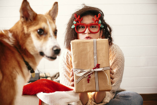 Стильная счастливая девушка с подарочной коробкой в руках
 - Фото, изображение