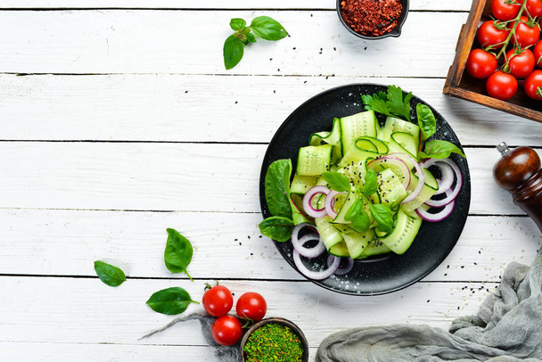 Salad of fresh cucumbers and onions. Top view. Free space for your text. - Foto, afbeelding