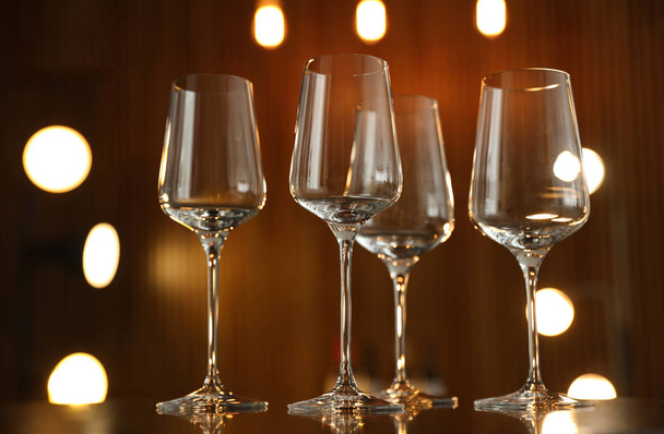 Empty wine glasses on table against blurred background - Photo, Image