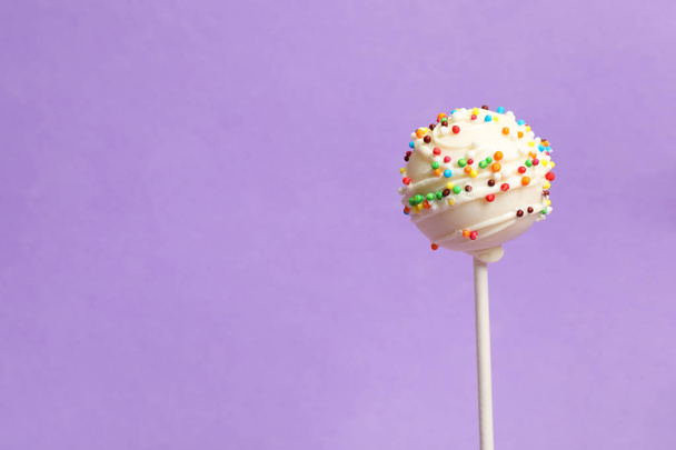 Bright delicious cake pop on color background. Space for text - 写真・画像