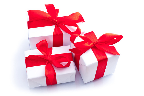 weiße Geschenkboxen mit roter Schleife isoliert auf weißem Grund - Foto, Bild