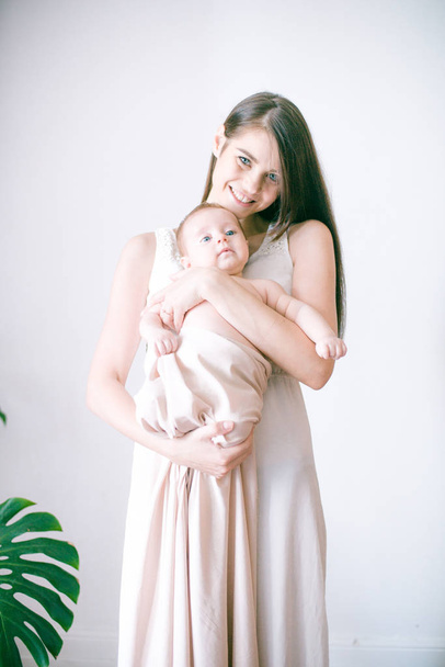 family, child and parenthood concept - happy smiling young mother with little baby at home - 写真・画像