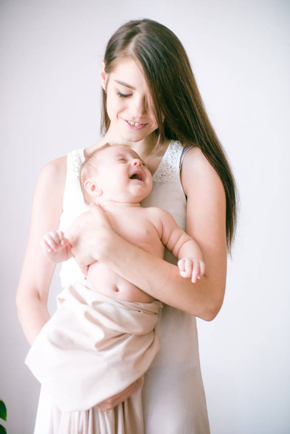 family, child and parenthood concept - happy smiling young mother with little baby at home - Photo, Image
