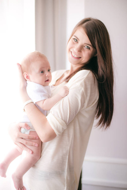 οικογένεια, παιδί και μητρότητα έννοια - ευτυχισμένος χαμογελώντας νεαρή μητέρα με μωρό στο σπίτι - Φωτογραφία, εικόνα