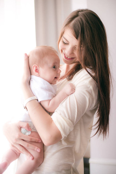 family, child and parenthood concept - happy smiling young mother with little baby at home - Foto, Bild