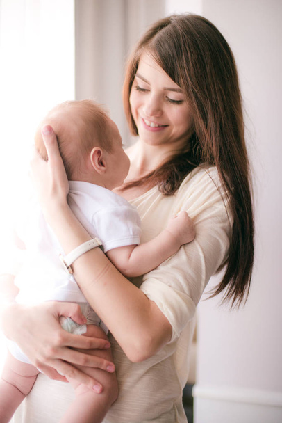 family, child and parenthood concept - happy smiling young mother with little baby at home - Foto, Imagen