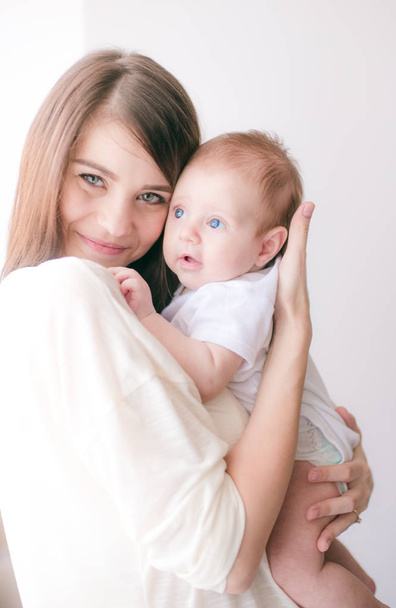 family, child and parenthood concept - happy smiling young mother with little baby at home - Photo, image