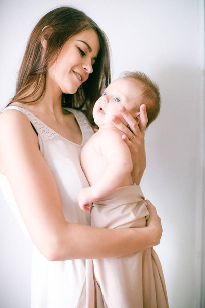 family, child and parenthood concept - happy smiling young mother with little baby at home - Foto, afbeelding