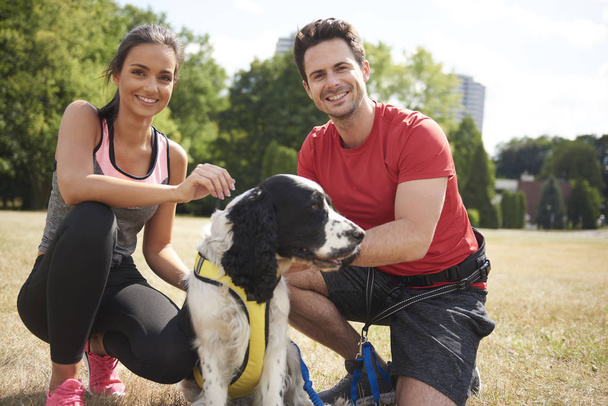 Smiling couple and dog after workout on the fresh air  - Valokuva, kuva