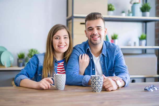 Молода пара робить перерву, випивши чашку кави, дуже щаслива за переїзд в новий будинок
 - Фото, зображення