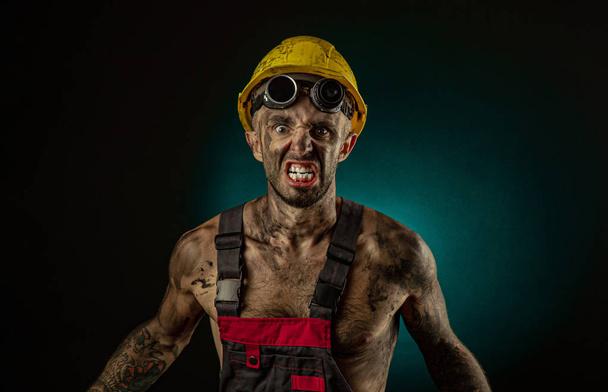 Портрет щасливого усміхненого вугільного шахтаря з руками, схрещеними на темному тлі
 - Фото, зображення