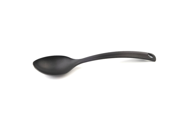 Black kitchen spoon utensils or kitchenware closeup isolated on white background - Photo, Image