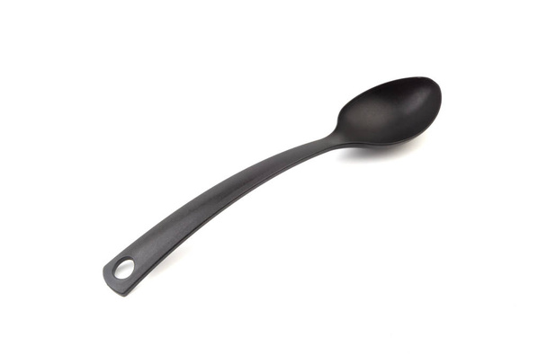 Black kitchen spoon utensils or kitchenware closeup isolated on white background - Photo, Image