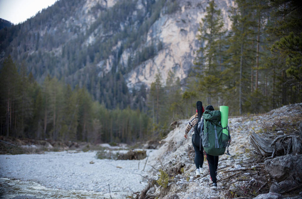 Dvě mladé chodící ženy v lese u vodního toku-Dolomity, Itálie - Fotografie, Obrázek