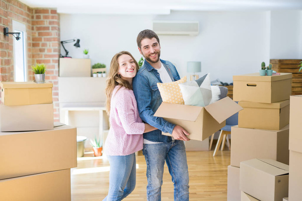 Молодая красивая пара очень счастливы вместе держа картонные коробки переезда в новый дом
 - Фото, изображение