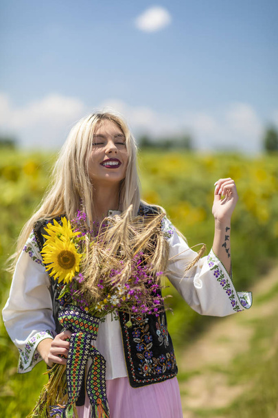 Beautiful girl in traditional costume in a field - Fotografie, Obrázek