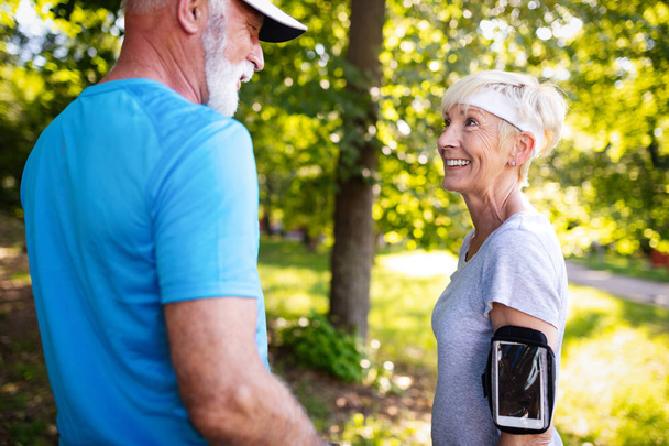 Senior couple jogging and running outdoors in nature - Fotoğraf, Görsel