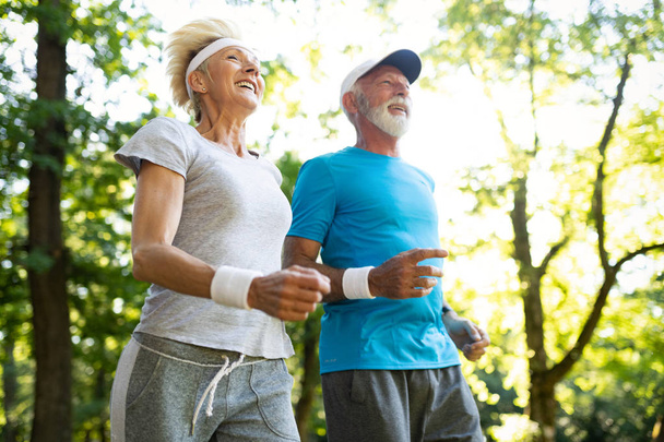 Happy senior couple staying fit by exercise jogging - Fotoğraf, Görsel