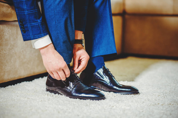 An elegant man puts on black, leather, formal shoes. - Fotoğraf, Görsel