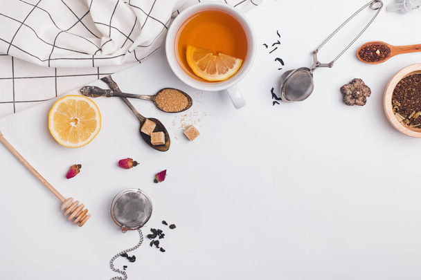 Creative composition witn variety of tea, sugar, lemon and other accessories for making tea - Foto, Bild
