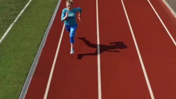 Sportive blonde woman running at open stadium - Video