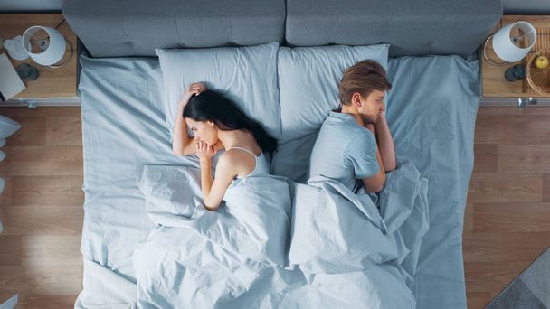 Quarrelling Young Couple in the Bed, Young People Lying Turned Away From Each other and Lay on Their Sides Holding Grudges and Being Offended - Foto, Bild