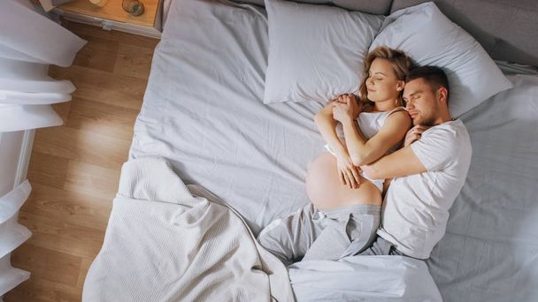 Happy Young Couple Sleeping Together in the Bed, Sweet Loving Young People Holding Each other while Sleeping. Beautiful Woman is Pregnant, Loving Partner Supports Her By Being there For Her. - Foto, Bild