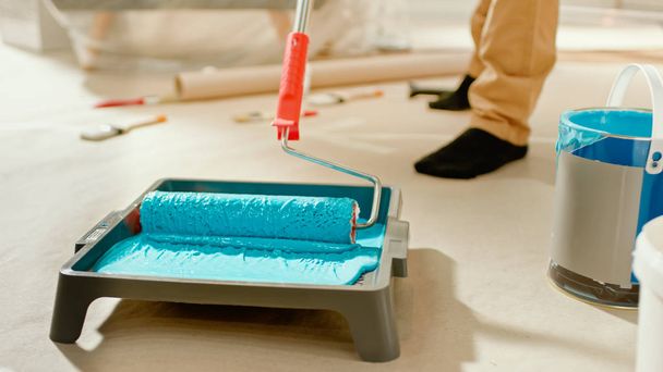 Close Up Shot of a Man applying Light Blue Paint on a Roller with Long Handle. Paint is in the Tray. Room Renovations at Home. - Foto, imagen