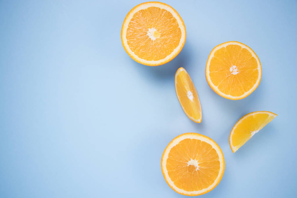 Pieces of citrus on a blue background. - Fotó, kép