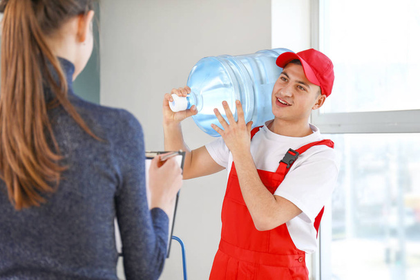 Чоловік доставляє пляшку води клієнту
 - Фото, зображення
