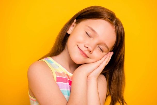 Close up photo of pretty child closing eyes sleeping wearing singlet isolated over yellow background - Foto, Imagen