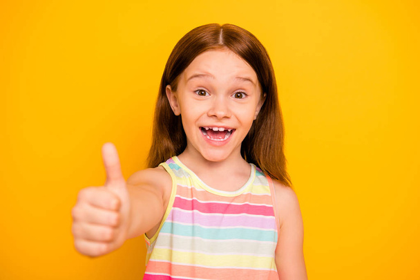 Portrait of charming cute kid raising thumb up screaming shouting wearing colorful singlet isolated over yellow background - Fotografie, Obrázek