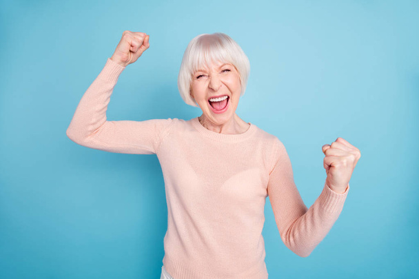 Portrait of cheerful lady shouting yeah raising fists wearing pastel sweater isolated over blue background - Φωτογραφία, εικόνα