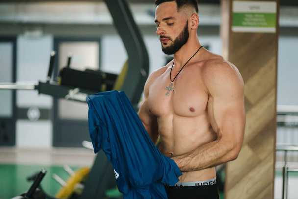 Μούσι bodybuilder αλλαγή t-shint στο γυμναστήριο - Φωτογραφία, εικόνα
