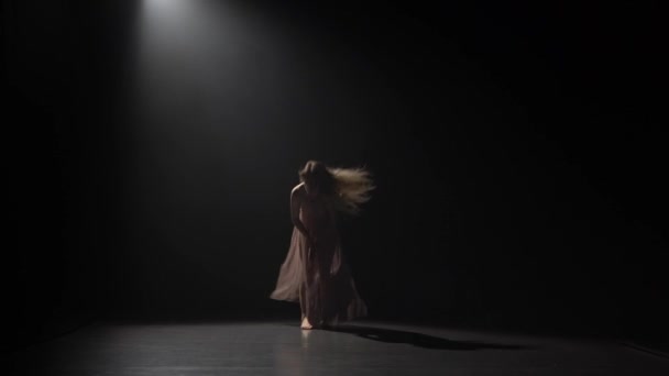 Motion of a maiden dancing contemp in dark studio. - Materiaali, video